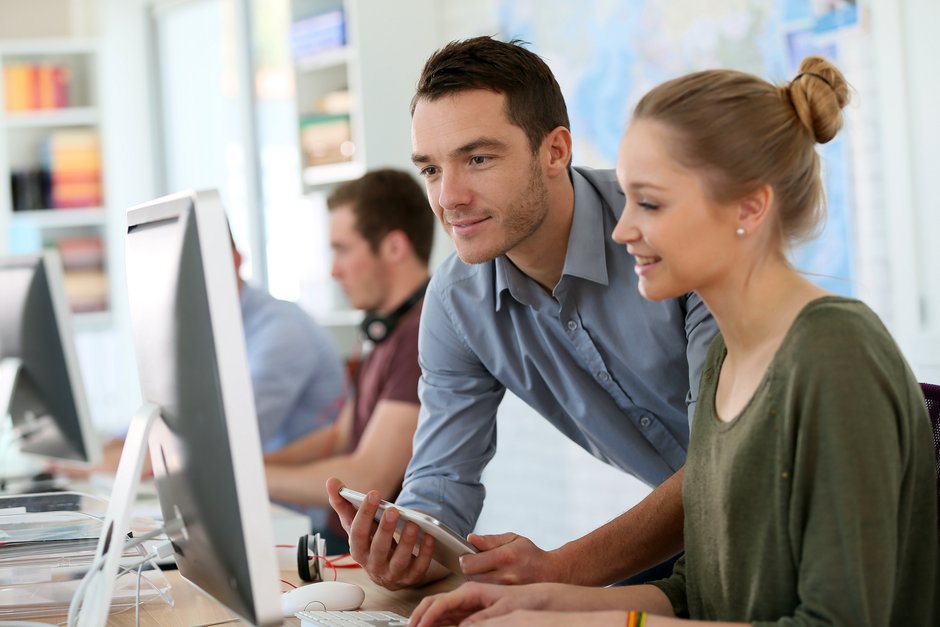 Ein junger Mann und eine junge Frau arbeiten gemensam an einem Computer